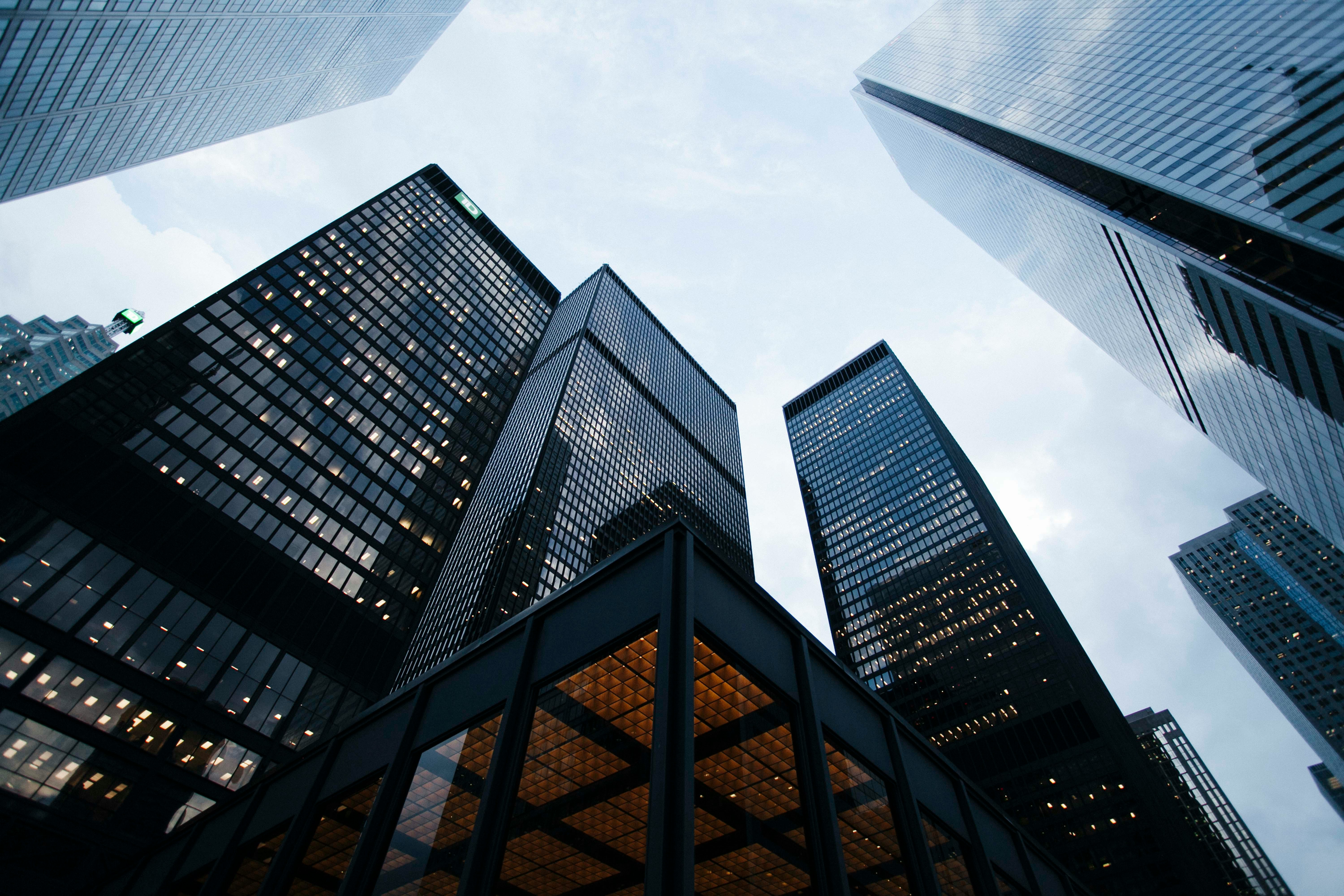 Dramatic upward view of glass curtain-wall skyscrapers against the sky