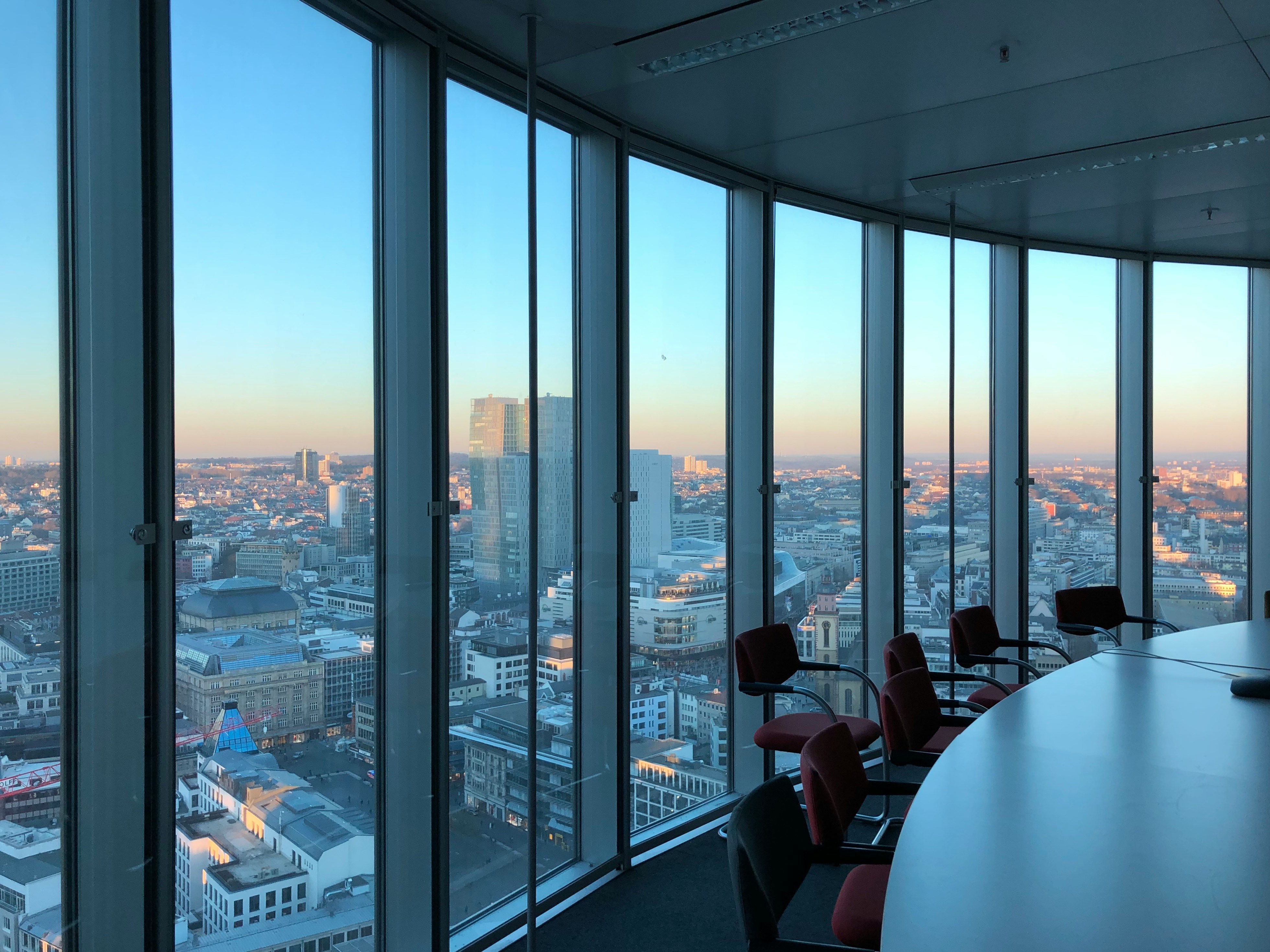 Sleek modern corporate boardroom with floor-to-ceiling windows and a city view