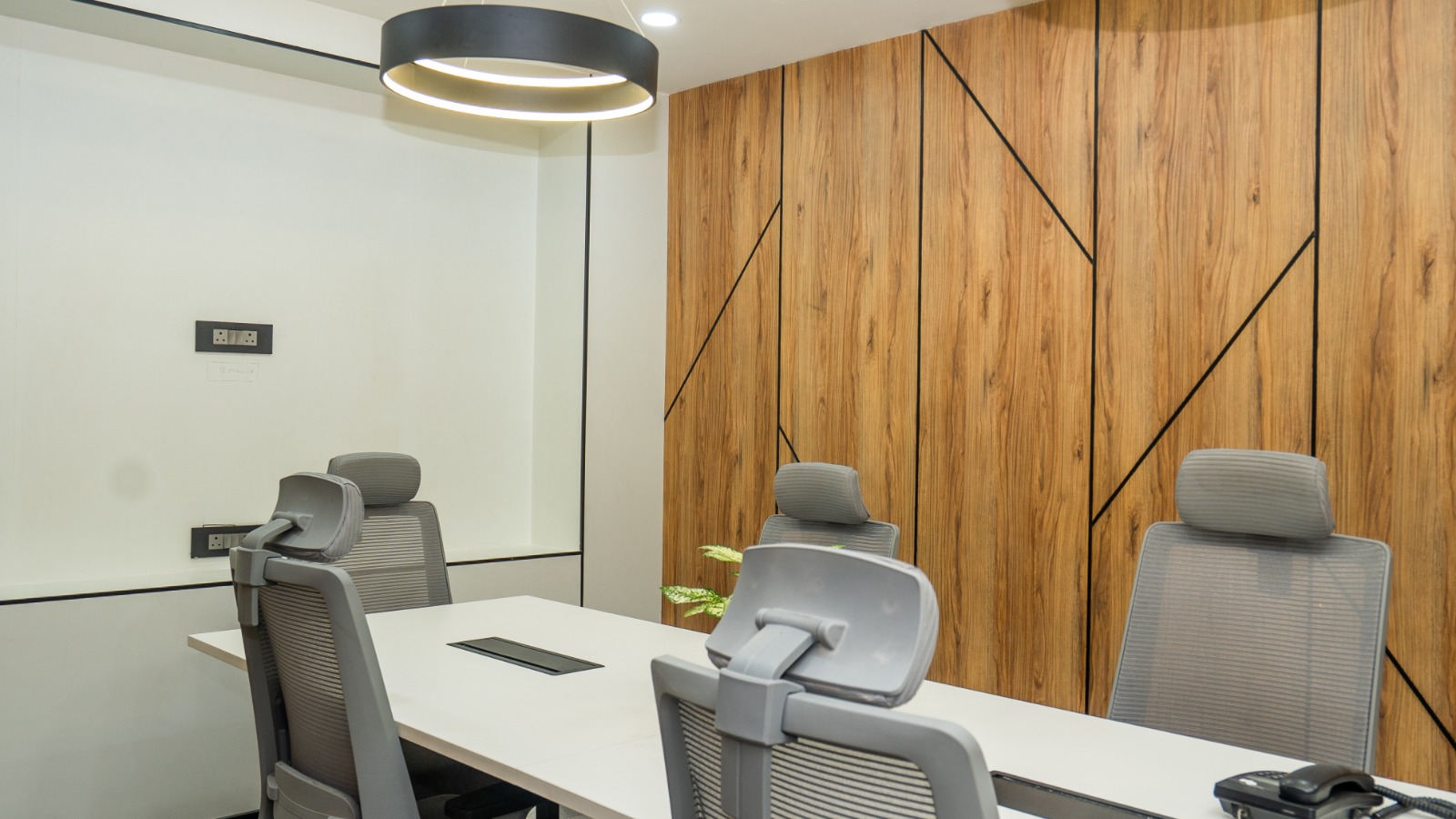 Meeting room with neutral wall panelling, acoustic panels, and a six-seat conference table at Valorium Ventures office interior