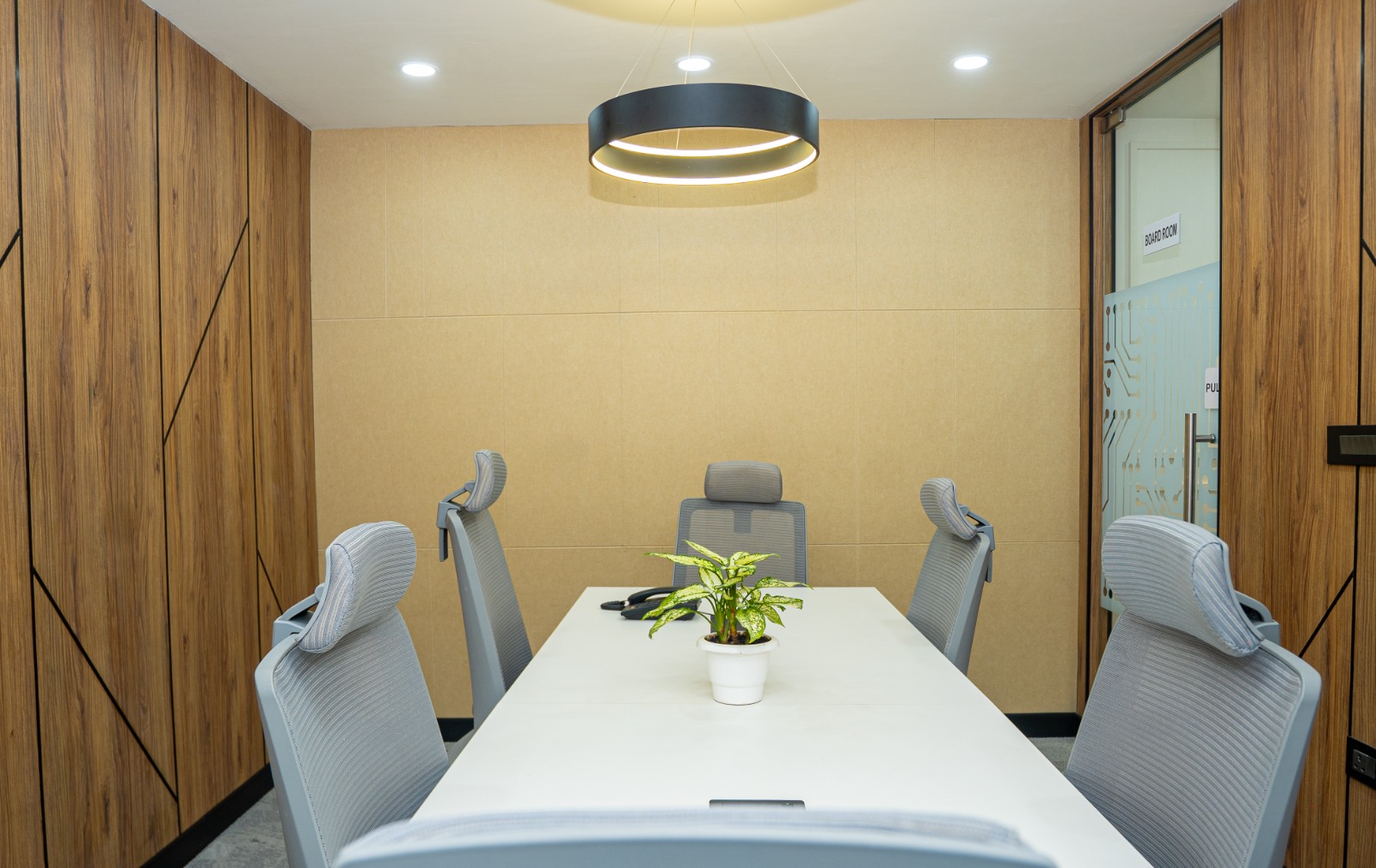 Meeting room with lacquered glass writing board and soft neutral finishes at Valorium Ventures office interior