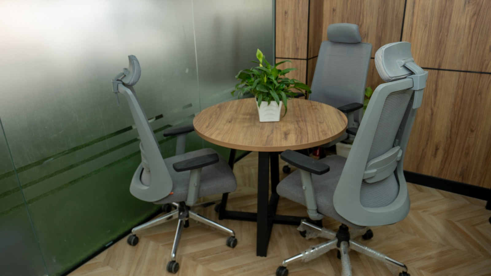 Discussion desk with lacquered glass logo panel backdrop in Valorium Ventures office interior