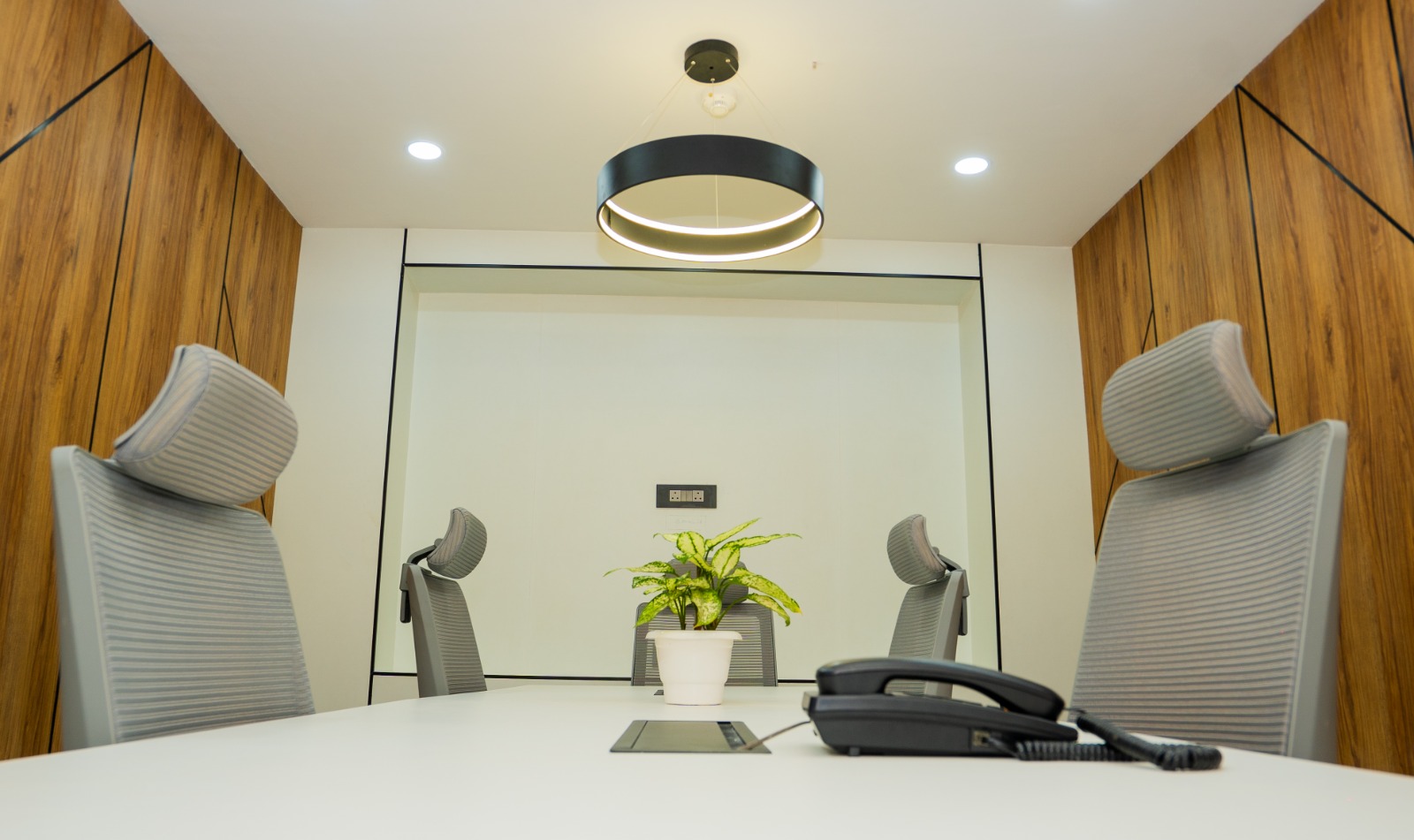 Conference room angle showing acoustic wall panelling and pendant lighting in Valorium Ventures office interior