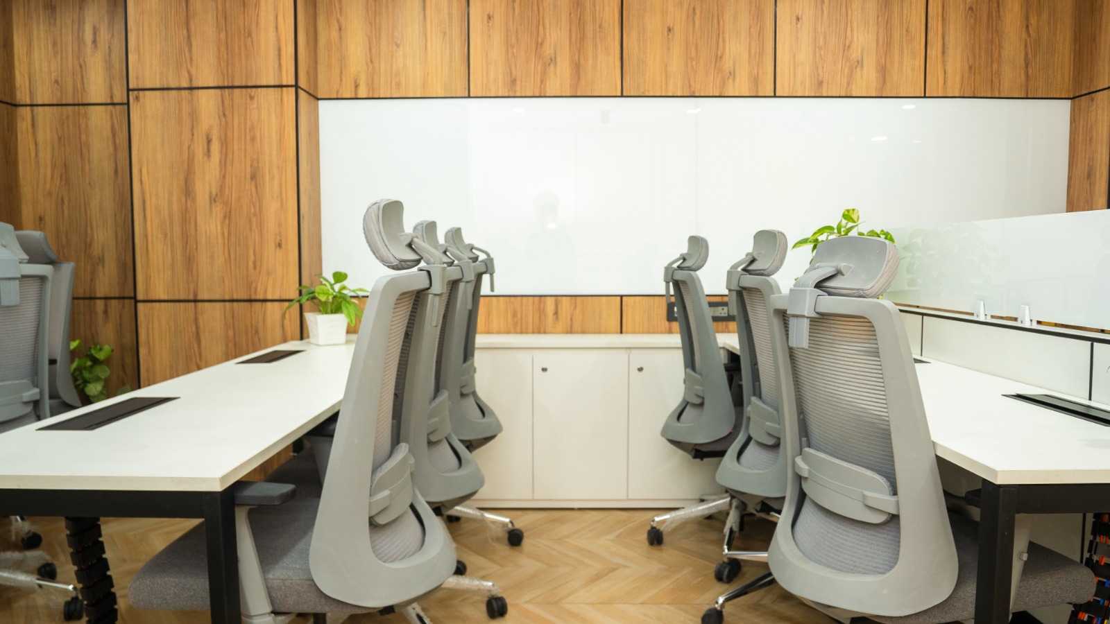 Workstations with divider panels and neutral cabinetry in Valorium Ventures office interior