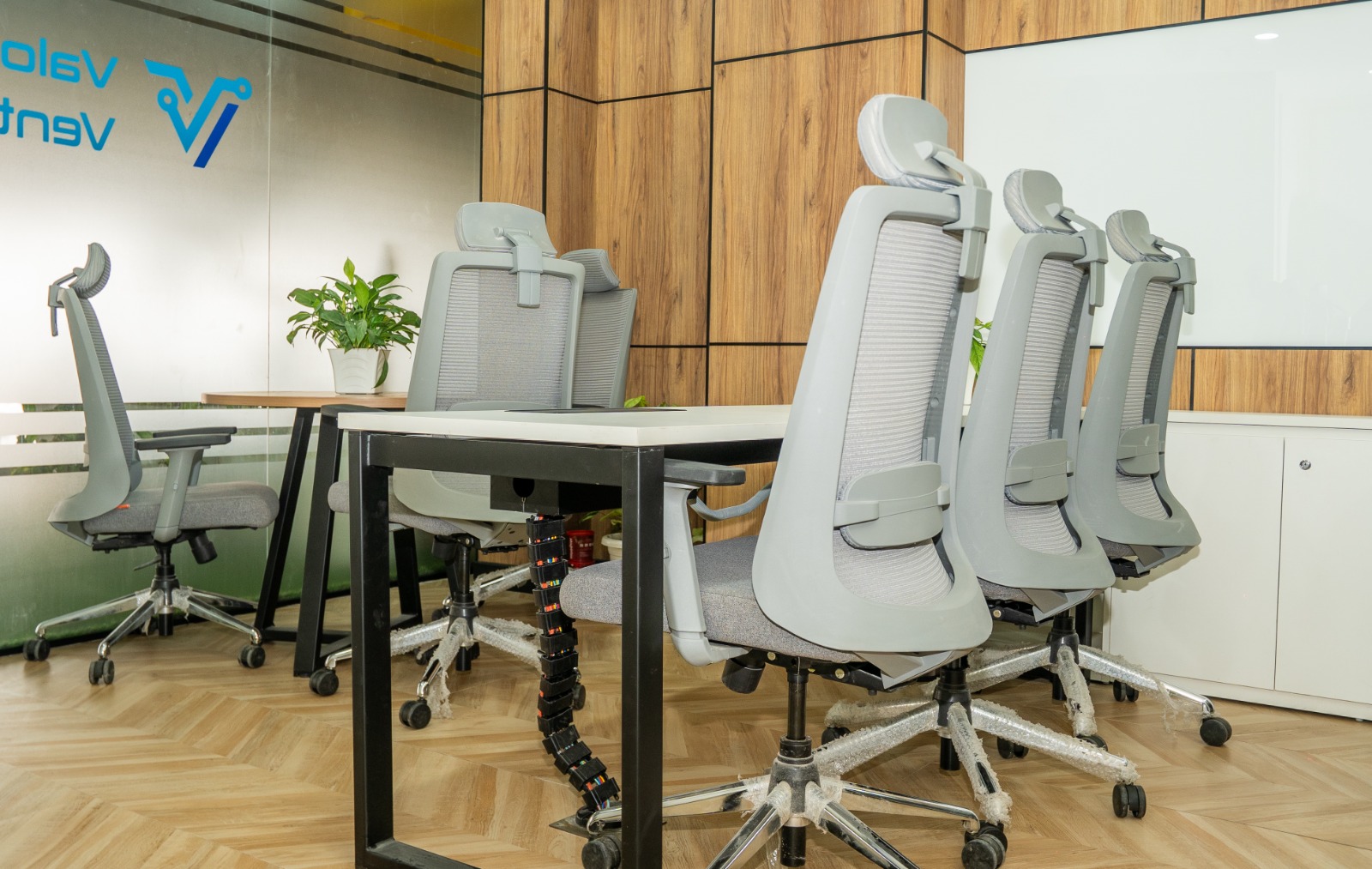 Compact workstation cluster with storage and neutral palette finishes at Valorium Ventures office interior
